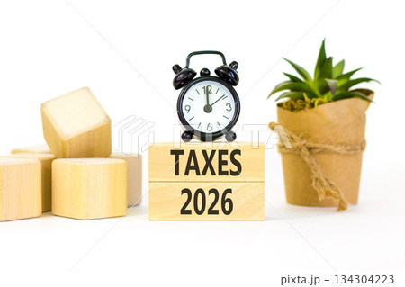Taxes 2026 new year symbol. Concept words Taxes 2026 on beautiful wooden blocks. Beautiful white paper background. Beautiful black alarm clock. Business and taxes 2026 new year concept. Copy space. 134304223