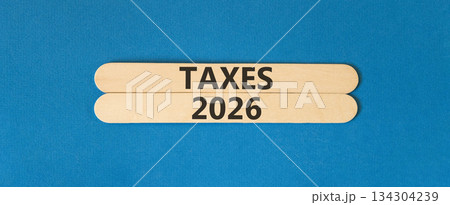 Taxes 2026 new year symbol. Concept words Taxes 2026 on beautiful wooden sticks. Beautiful blue paper background. Business and taxes 2026 new year concept. Copy space. Taxes 2026 new year symbol. Concept words Taxes 2026 on beautiful wooden sticks. Beautiful blue paper background. Business and taxes 2026 new year concept. Copy space. 134304239