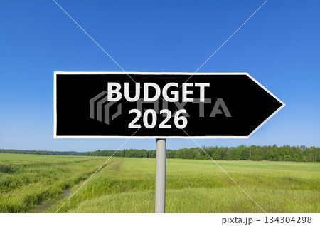 Budget 2026 symbol. Concept words Budget 2026 on beautiful black road sign. Beautiful green grass field forest and blue sky background. Business and budget 2026 concept. Copy space. Budget 2026 symbol. Concept words Budget 2026 on beautiful black road sign. Beautiful green grass field forest and blue sky background. Business and budget 2026 concept. Copy space. 134304298