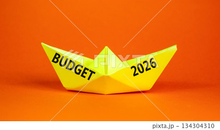 Budget 2026 symbol. Concept words Budget 2026 on beautiful yellow paper boat. Beautiful orange paper background. Business and budget 2026 concept. Copy space. 134304310