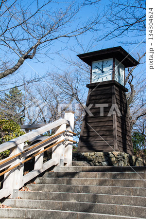 快晴の空と冬の枝木に囲まれ石段の上に設置された歴史的な木製の時計台 東京都の王子の飛鳥山公園にて 快晴の空と冬の枝木に囲まれ石段の上に設置された歴史的な木製の時計台 東京都の王子の飛鳥山公園にて 134304624