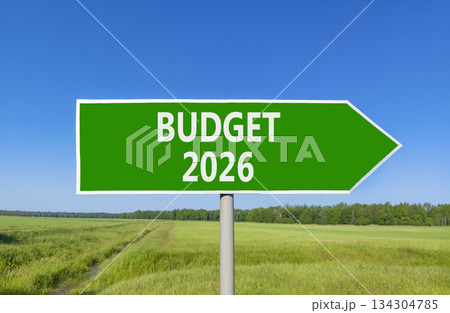 Budget 2026 symbol. Concept words Budget 2026 on beautiful green road sign. Beautiful green grass field forest and blue sky background. Business and budget 2026 concept. Copy space. Budget 2026 symbol. Concept words Budget 2026 on beautiful green road sign. Beautiful green grass field forest and blue sky background. Business and budget 2026 concept. Copy space. 134304785