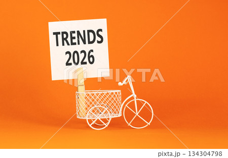 Trends 2026 symbol. Concept words Trends 2026 on beautiful white paper on wooden clothespin. Beautiful orange background. Beautiful miniature bicycle. Business Trends 2026 new year concept. Copy space 134304798