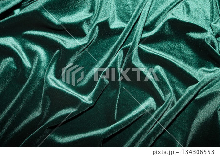 Green velvet fabric showing soft folds and creases, creating luxurious background texture 134306553