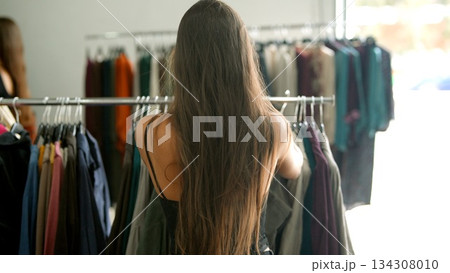 A woman is shopping for stylish and fashionable clothing in a trendy boutique today 134308010