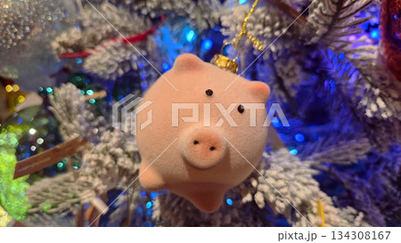 Festive pig ornament on christmas tree with colorful lights for holiday decor 134308167