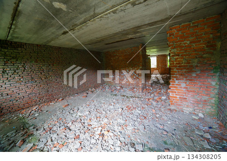 Desolate interior of abandoned building with brick walls and rubble Desolate interior of abandoned building with brick walls and rubble 134308205