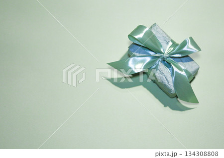 Mint color gift box wrapped with satin ribbon on a minimal festive background 134308808
