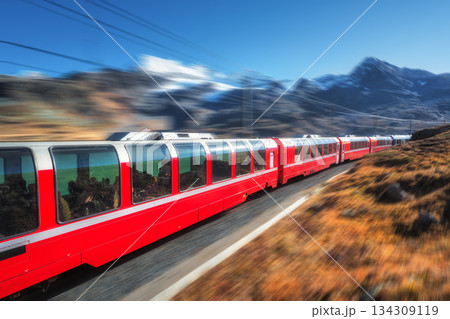 High speed red train is moving in swiss alps. Motion blur effect High speed red train is moving in swiss alps. Motion blur effect 134309119