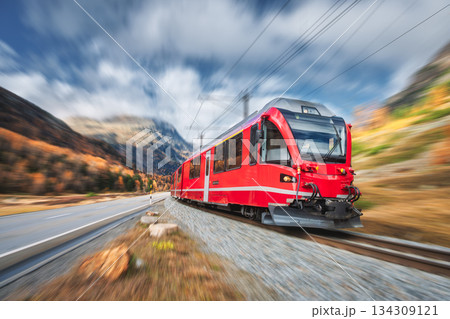 Red modern passenger train is moving on railway in swiss alps 134309121