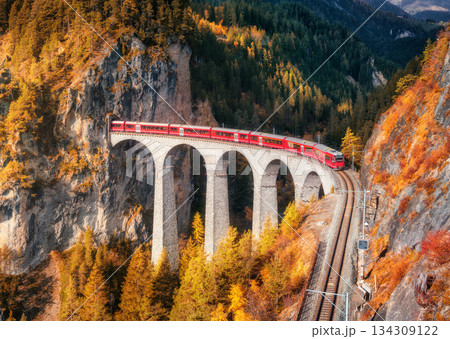 Aerial view of modern red train on Landwasser viaduct in autumn Aerial view of modern red train on Landwasser viaduct in autumn 134309122