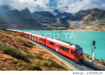 High speed red train with motion blur effect near lake High speed red train with motion blur effect near lake 134309124