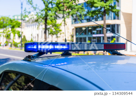 Police vehicle with light bar and antenna in urban setting Police vehicle with light bar and antenna in urban setting 134309544