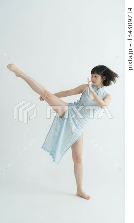 白背景でカンフーの蹴り技を披露するチャイナドレスの日本人女性 白背景でカンフーの蹴り技を披露するチャイナドレスの日本人女性 134309714