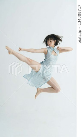 チャイナドレスで華麗に飛び蹴りをするカンフー女性 チャイナドレスで華麗に飛び蹴りをするカンフー女性 134309717