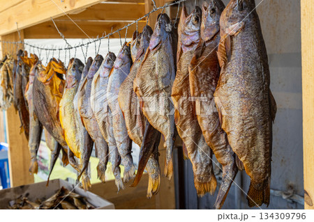 Dried fish hanging at rustic outdoor market stall during daytime Dried fish hanging at rustic outdoor market stall during daytime 134309796