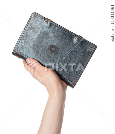 Hand holding an old antique book, isolated on transparent background. Ideal for education, history, literature, archival, and vintage-themed design projects 134311461