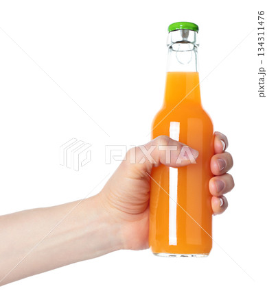 Hand holding a glass bottle filled with orange juice, isolated on transparent background. Suitable for food, drink, freshness, citrus, and healthy lifestyle projects 134311476