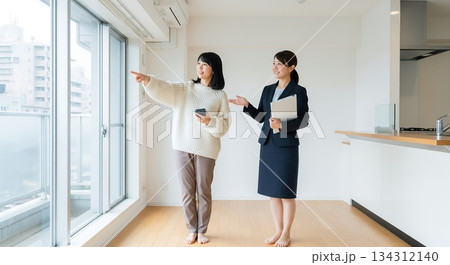 マンションの内見をしている女性と、案内する不動産業者の女性 134312140