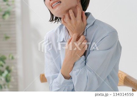 首を掻きむしる女性 134314550