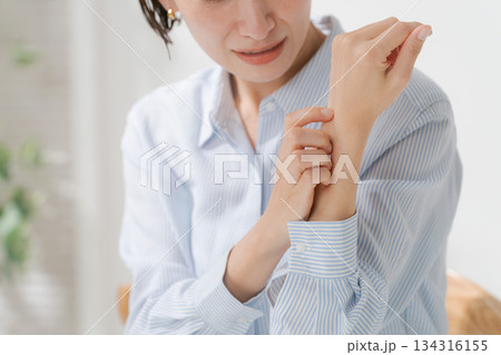 手首の不調を訴える女性 134316155