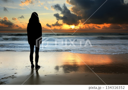 Person Standing on Beach at Sunset Experiencing Transformative Moments Along the Shoreline Person Standing on Beach at Sunset Experiencing Transformative Moments Along the Shoreline 134316352