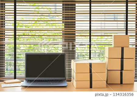 Modern Home Office Setup with Laptop and Shipping Boxes for Online Business Success Modern Home Office Setup with Laptop and Shipping Boxes for Online Business Success 134316356