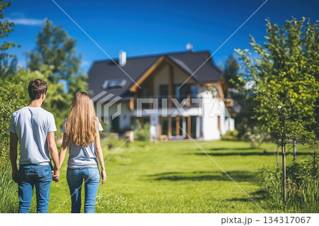 Couple Holding Hands Walking Together at Home in Beautiful Green Landscape Couple Holding Hands Walking Together at Home in Beautiful Green Landscape 134317067