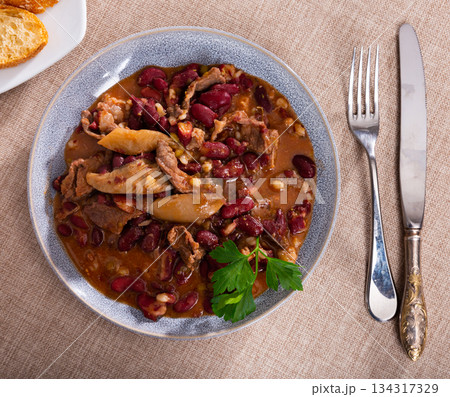 Stewed beans with mushrooms on a ceramic plate close up Stewed beans with mushrooms on a ceramic plate close up 134317329