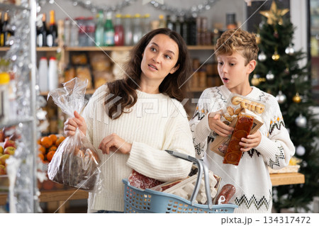 Mother and her son choose different products together for Christmas celebration in grocery supermarket Mother and her son choose different products together for Christmas celebration in grocery supermarket 134317472