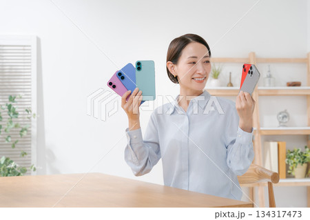 いろいろな色のスマホカバーを持つ女性 いろいろな色のスマホカバーを持つ女性 134317473