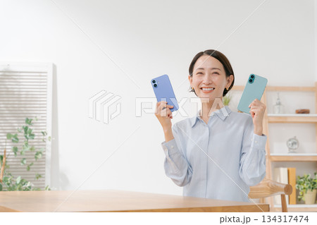 いろいろな色のスマホカバーを持つ女性 134317474