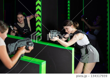 Girls play laser tag, jokingly fight with light weapons Girls play laser tag, jokingly fight with light weapons 134317939