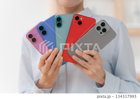 いろいろな色のスマホカバーを持つ女性 134317993