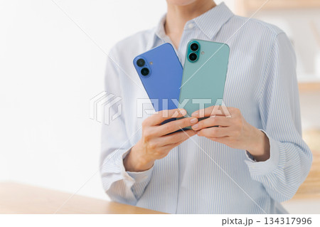 いろいろな色のスマホカバーを持つ女性 134317996