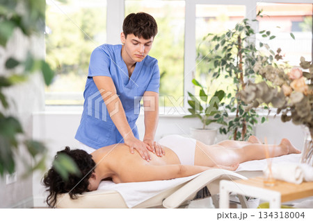 Young guy doing a back massage to adult woman 134318004