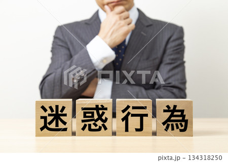 「迷惑行為」と書かれたブロックとビジネスマン 134318250