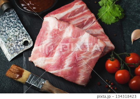Raw meat. Raw pork ribs from the back with meat on a black background. background image 134318423
