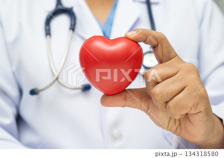 Doctor holding a red heart in hospital. 134318580