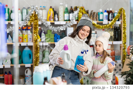 Mother and daughter choose for window cleaning spray and detergent together during Christmas at home improvement store 134320793