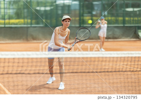 Female athlete plays tennis on open court Female athlete plays tennis on open court 134320795