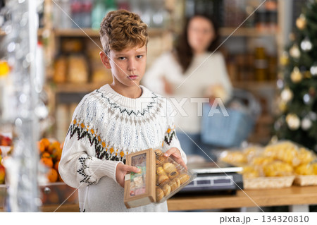 Boy with sweets quarrels with his mother in grocery Boy with sweets quarrels with his mother in grocery 134320810