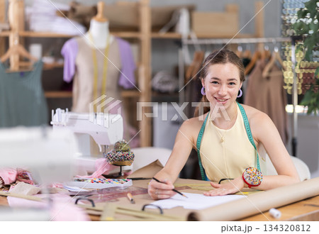 Girl seamstress to draw using patterns 134320812