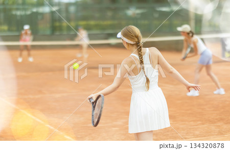 Female athlete plays tennis on open court Female athlete plays tennis on open court 134320878