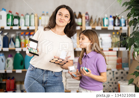 Woman with child family selects and studies label makeup cosmetic agent 134321008