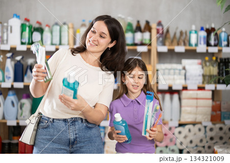 Woman with daughter choosing dental care products 134321009