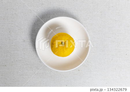 白い皿の中央に置かれた柚子 冬至や柑橘系の素材、和風のイメージ 134322679