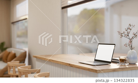 White screen laptop with coffee and book on counter table aside glass window in living room or cafe White screen laptop with coffee and book on counter table aside glass window in living room or cafe 134322835