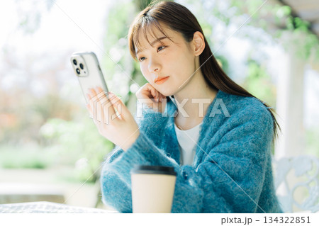 テラスでスマホを見る女性 134322851