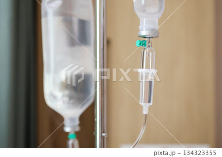 Close up medical intravenous IV drip in hospital background Close up medical intravenous IV drip in hospital background 134323355